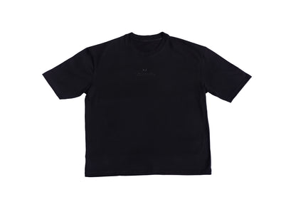 A black oversized T-shirt featuring a colorful graphic design with abstract patterns and text on the front, displayed against a white background.