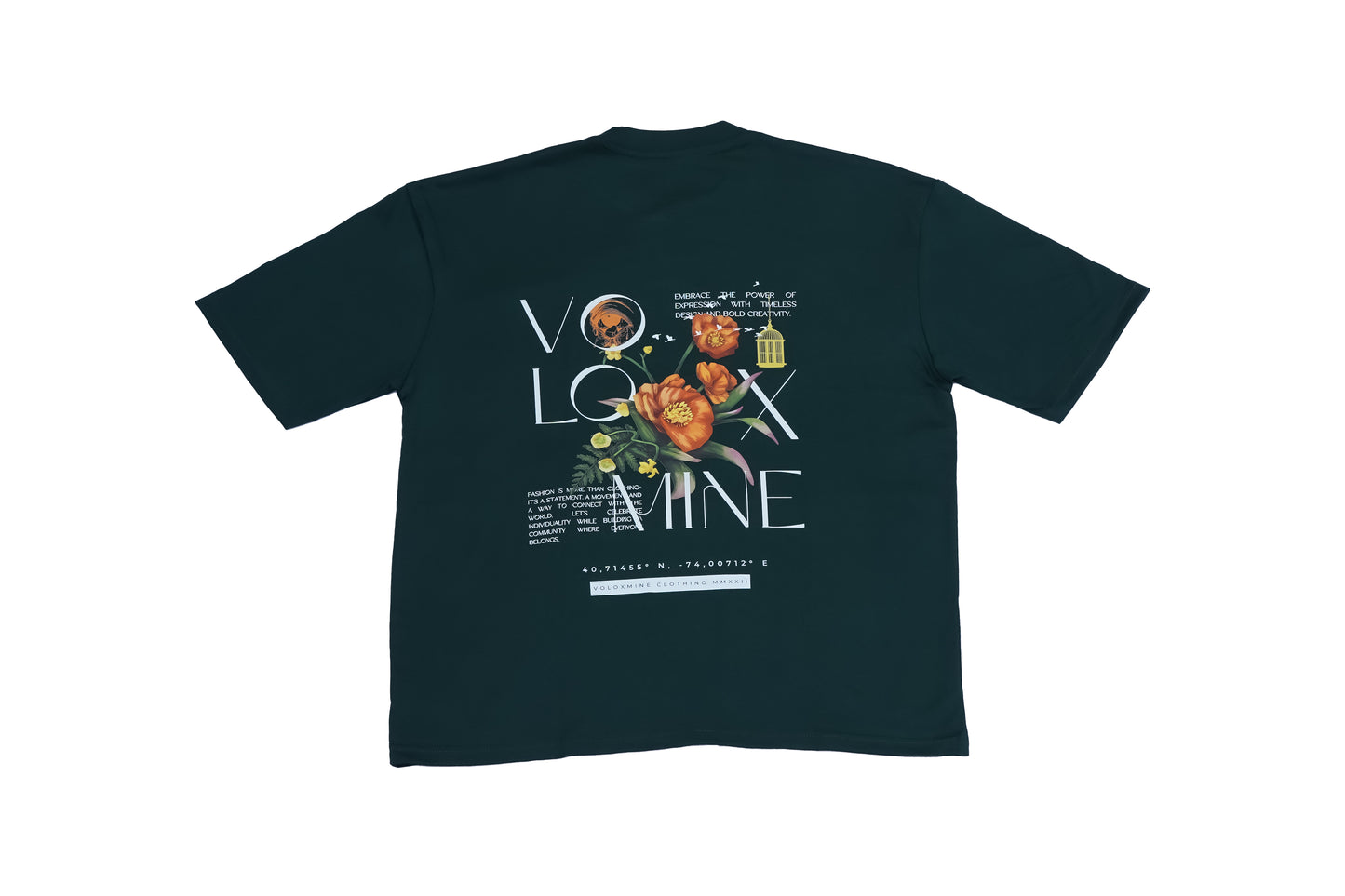 An oversized dark teal short-sleeve T-shirt featuring a bold "VOGUE" text design with floral elements and a small hanging object, displayed against a plain background.
